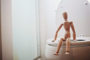 Stick figure sitting on a clean white toilet